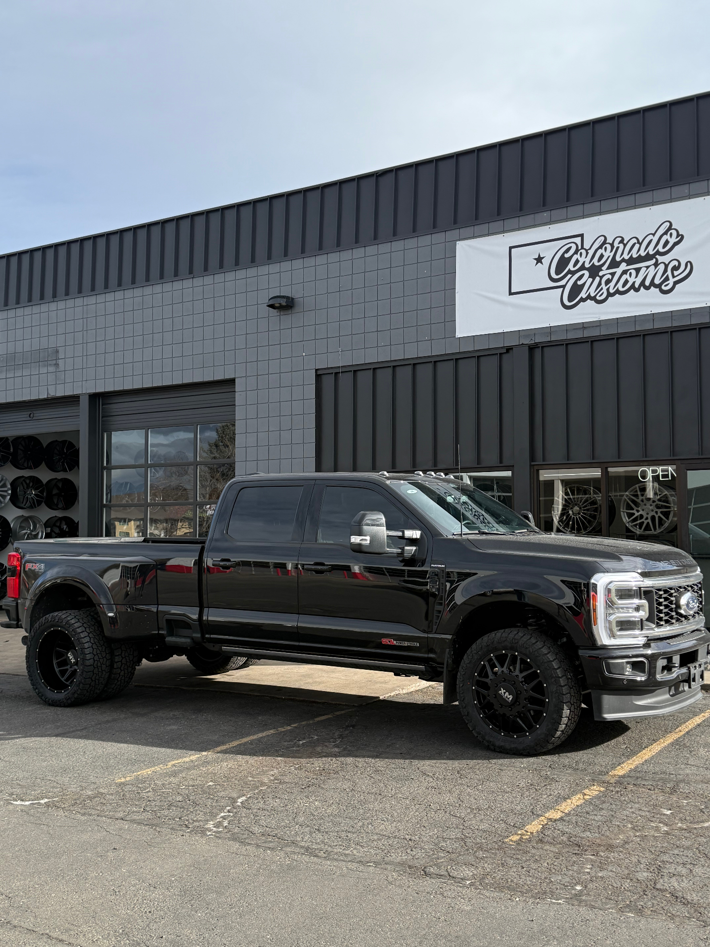 Black Ford truck parked outside Colorado Customs Wheel and Tires storefront