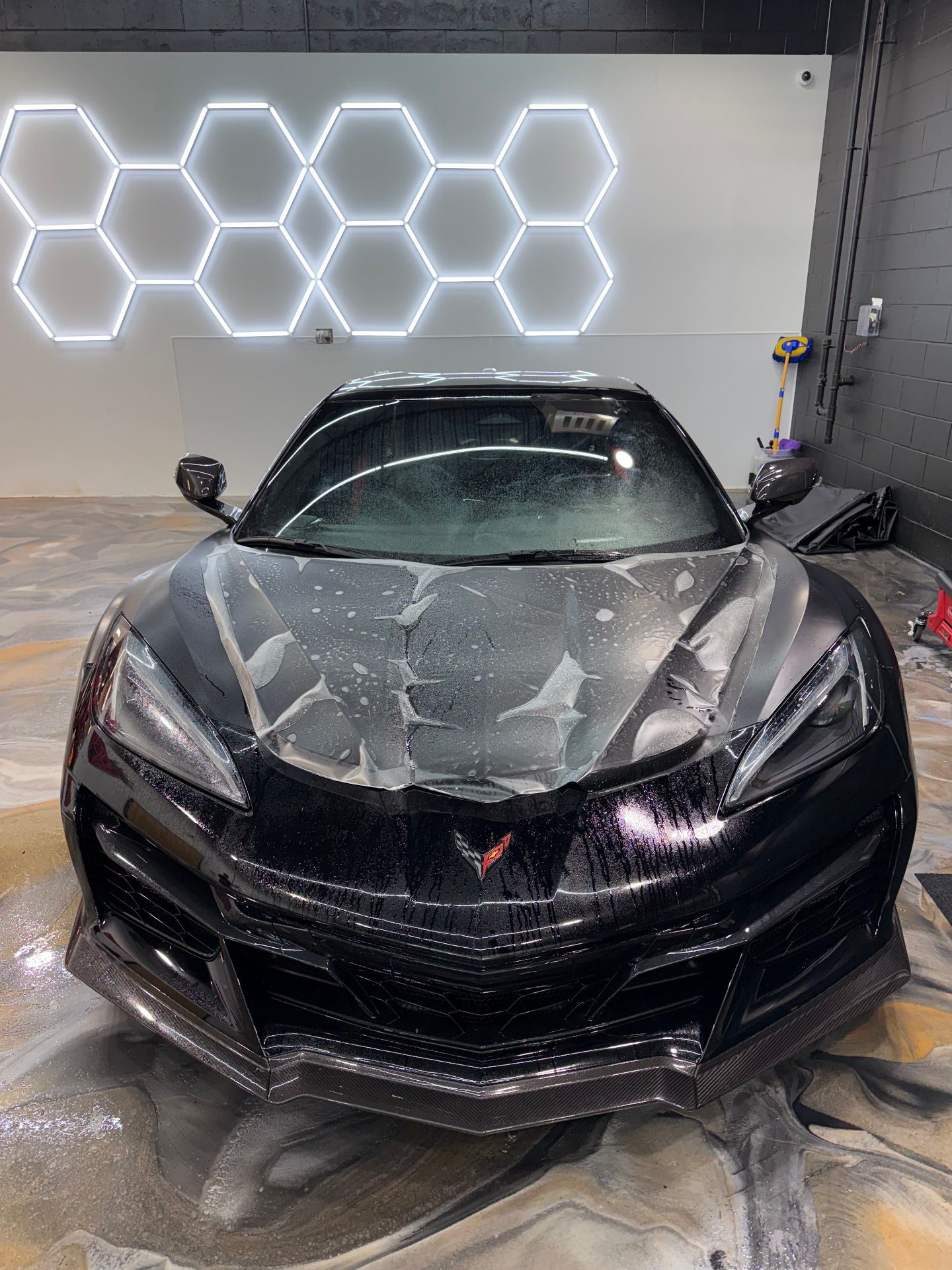 Front view of a black Corvette with hood paint protection film applied